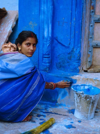 Mulher pintando a casa azul